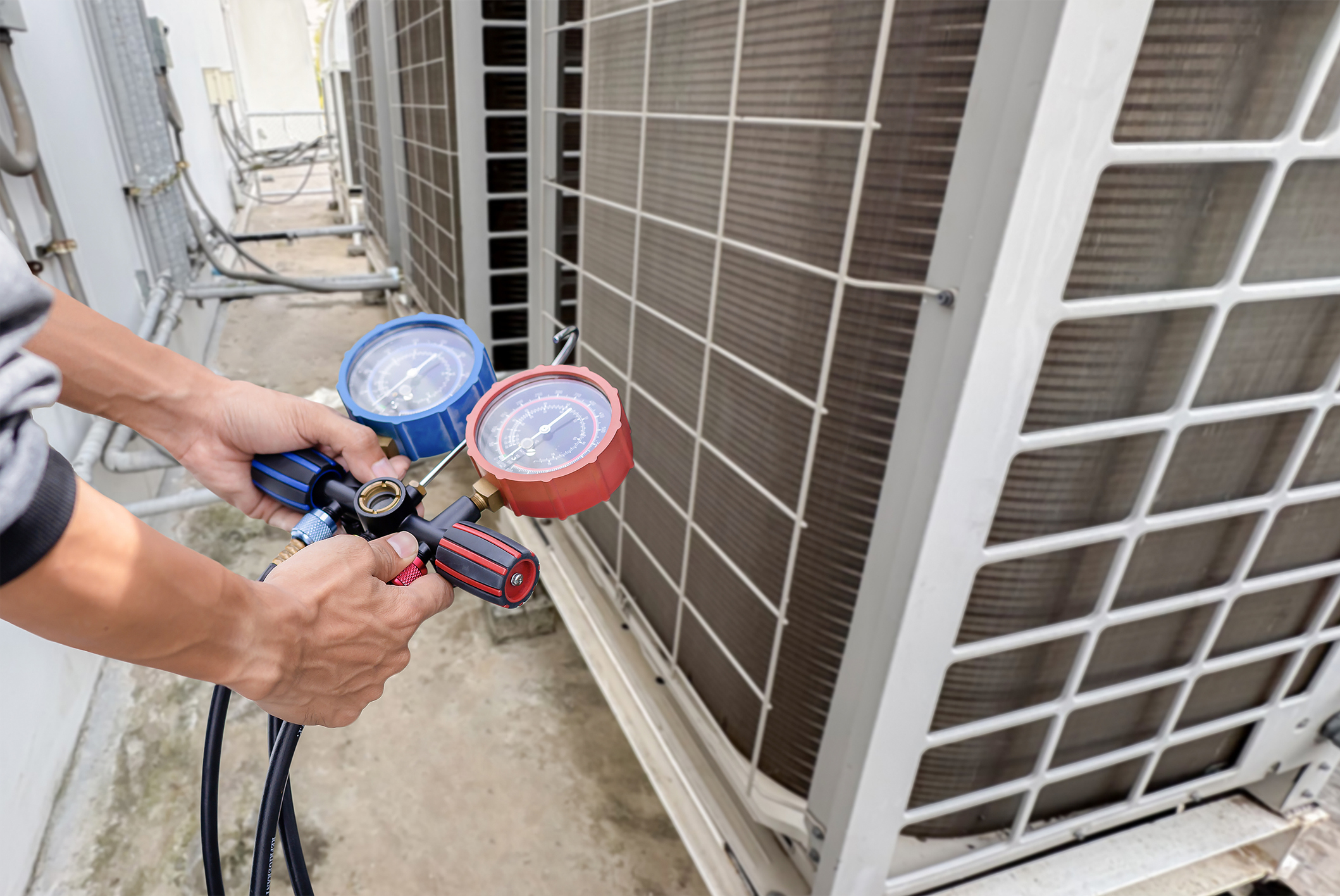 HVAC technician checking air conditioner refrigerant gauges during service in Mount Vernon, Ohio